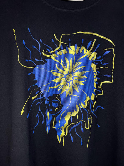 Melns t-krekls ar dizainu Ukrainas karoga krāsās. Ilustrēts sievietes profils ar dzeltenu saulespuķi zilos matos tuvlānā. Apdruka sietspiedes tehnikā.